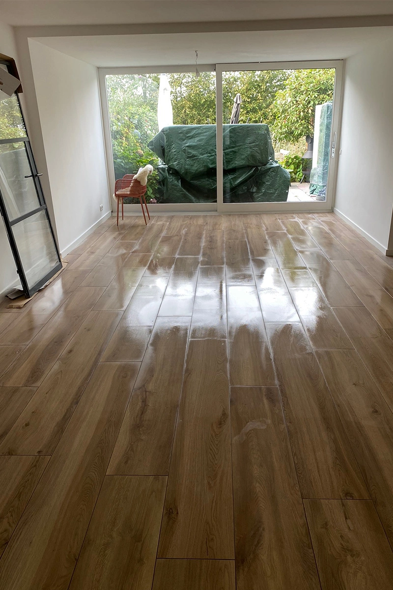 Houtlook tegels in een woonkamer, net gevoegd en schoon gedweild, geplaatst door Roy van den Bosch van VDB Tegelwerk.